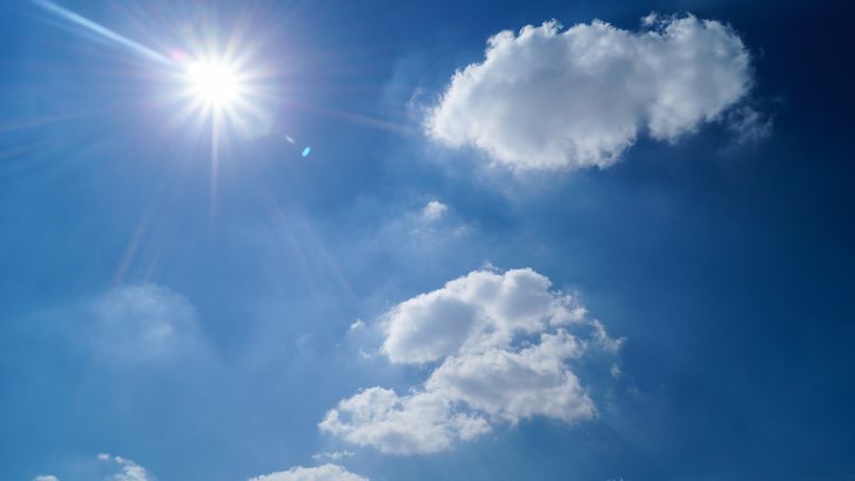 Vibrant blue sky with fluffy clouds and bright sun. Perfect cloudscape background.